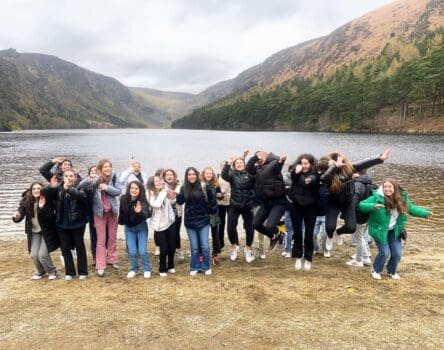 Grupo de ministay posando juntos frente a un lago en Irlanda