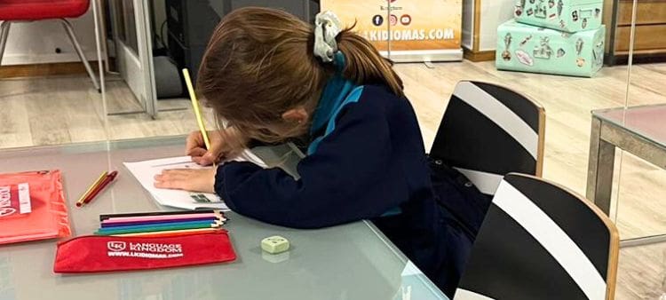 Aluman de primaria haciendo ejercicios de inglés concentrada