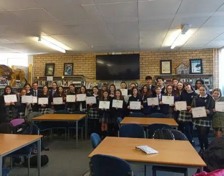 studiantes posando juntos en una clase con su certificado del programa de intercambio escolar