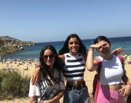 Estudiantes posando delante de una playa soleada en Malta