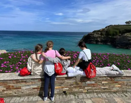 Niñas mirando al mar en un muro mostrando su amistad