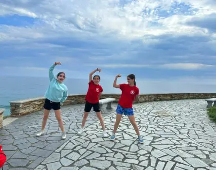 Niñas practicando gimnasia en un paseo junto al mar