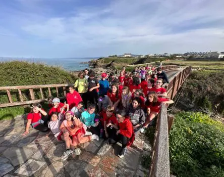 Estudiantes de un colegio sentados en el suelo de un paseo en Foz