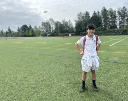 Adolescente con mochila LK en el cesped donde practica futbol en su año académico en Canadá