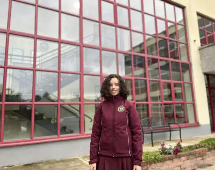 Estudiante con uniforme posando delante de su boarding school en Irlanda