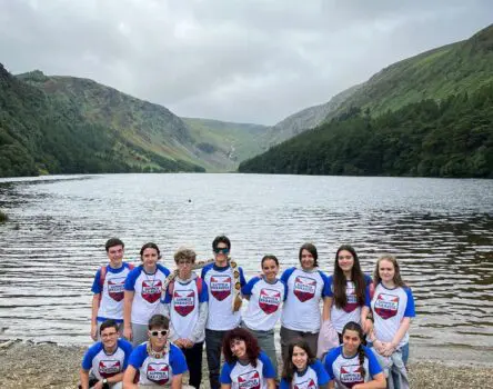 Chicos posando con camisetas de Language Kingdom frente a un lago irlandés