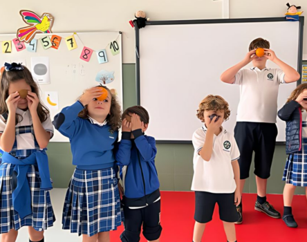 Niños de primaria en clase de extraescolares de inglés con su uniforme del colegio