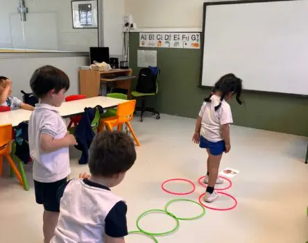 Niños practicando deporte en el aula mientras aprenden inglés