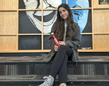 Estudiante sentada delante del aula de teatro en su boarding school