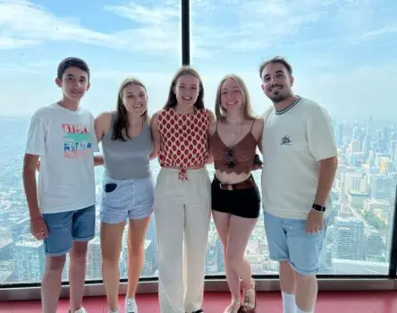 Jóvenes en verano posando frente a vistas desde un rascacielos