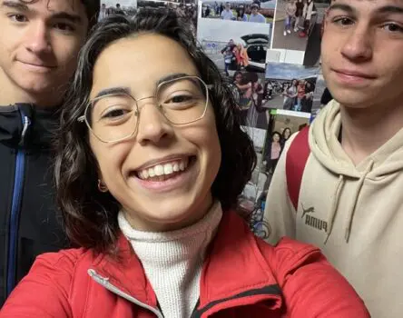 Monitora con sudadera LK con dos estudiantes