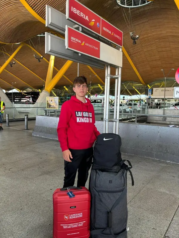 Chico posando con su sudadera de Language Kingdom esperando en ell aeropuerto a su vuelo