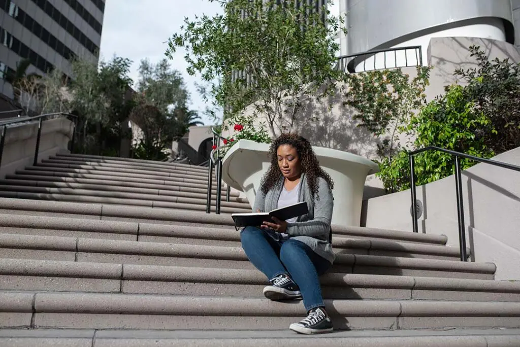 Estudiante sentada en las escaleras de la Universidad