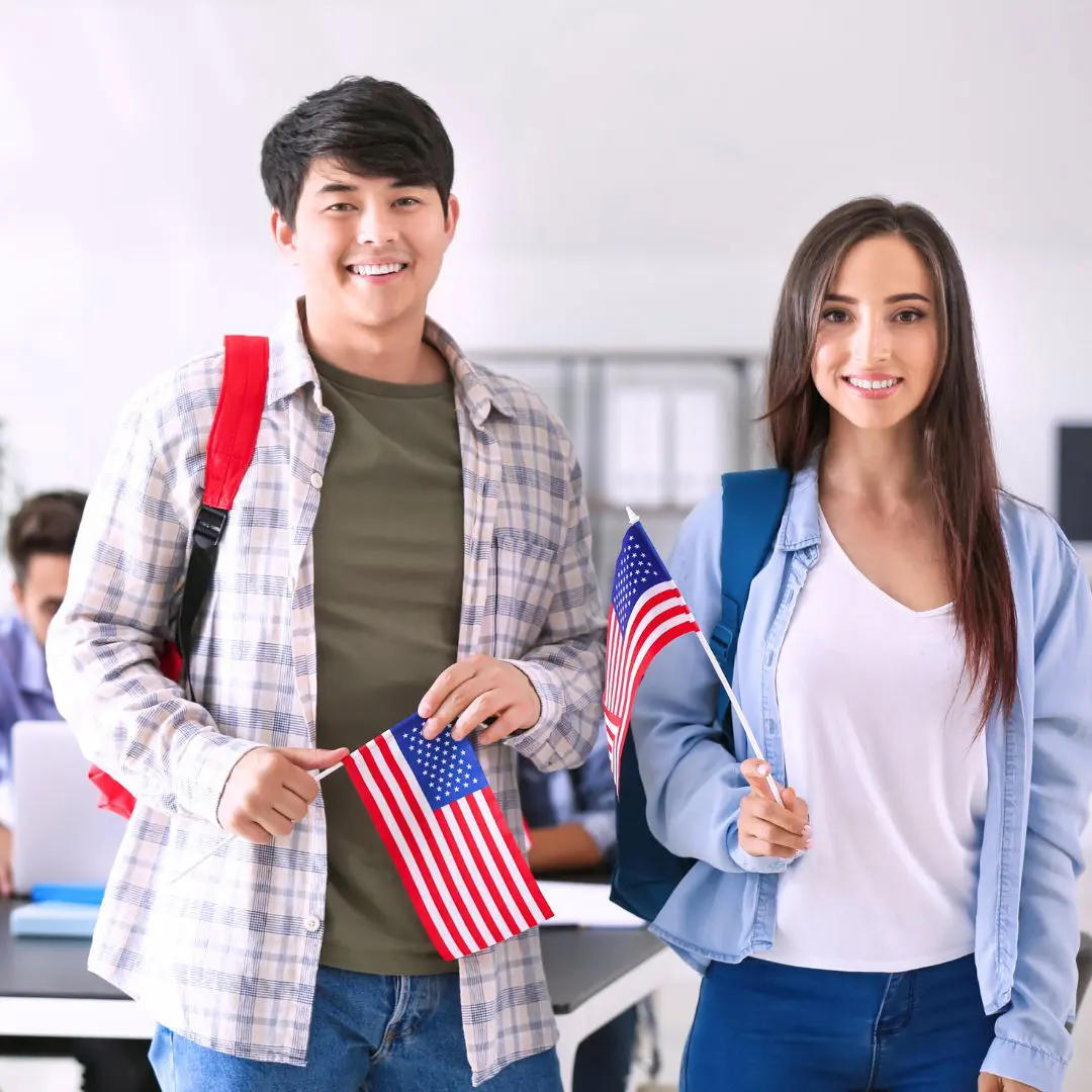 Dos estudiantes sujetando sus banderas tras obtener visados