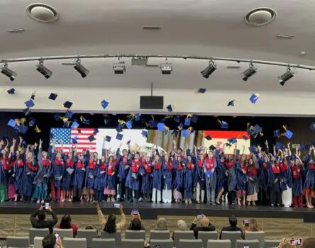 Estudiantes tirando sus birretes al aire en su graduación