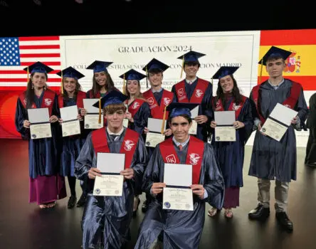 Estudiantes de Bachillerato americano sujetando sobre el escenario sus diplomas en la graduación 2024