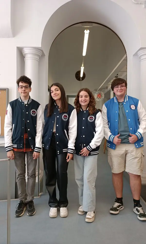 Estudiantes posando bajo un arco con sus sudaderas bda