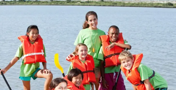 Monitora de campamento con niños en una actividad acuática