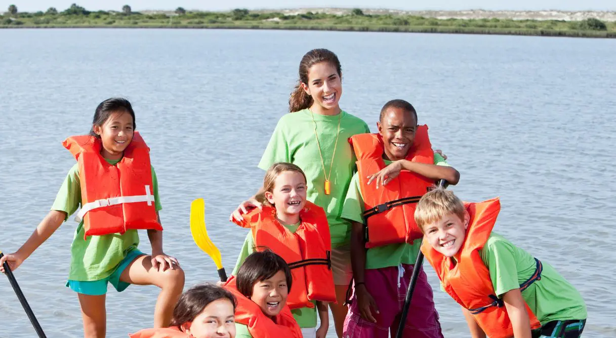 Monitora de campamento con niños en una actividad acuática
