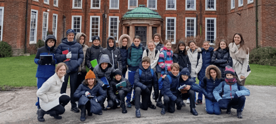 Chicos de un grupo de ministay integración posando frente a la puerta del colegio