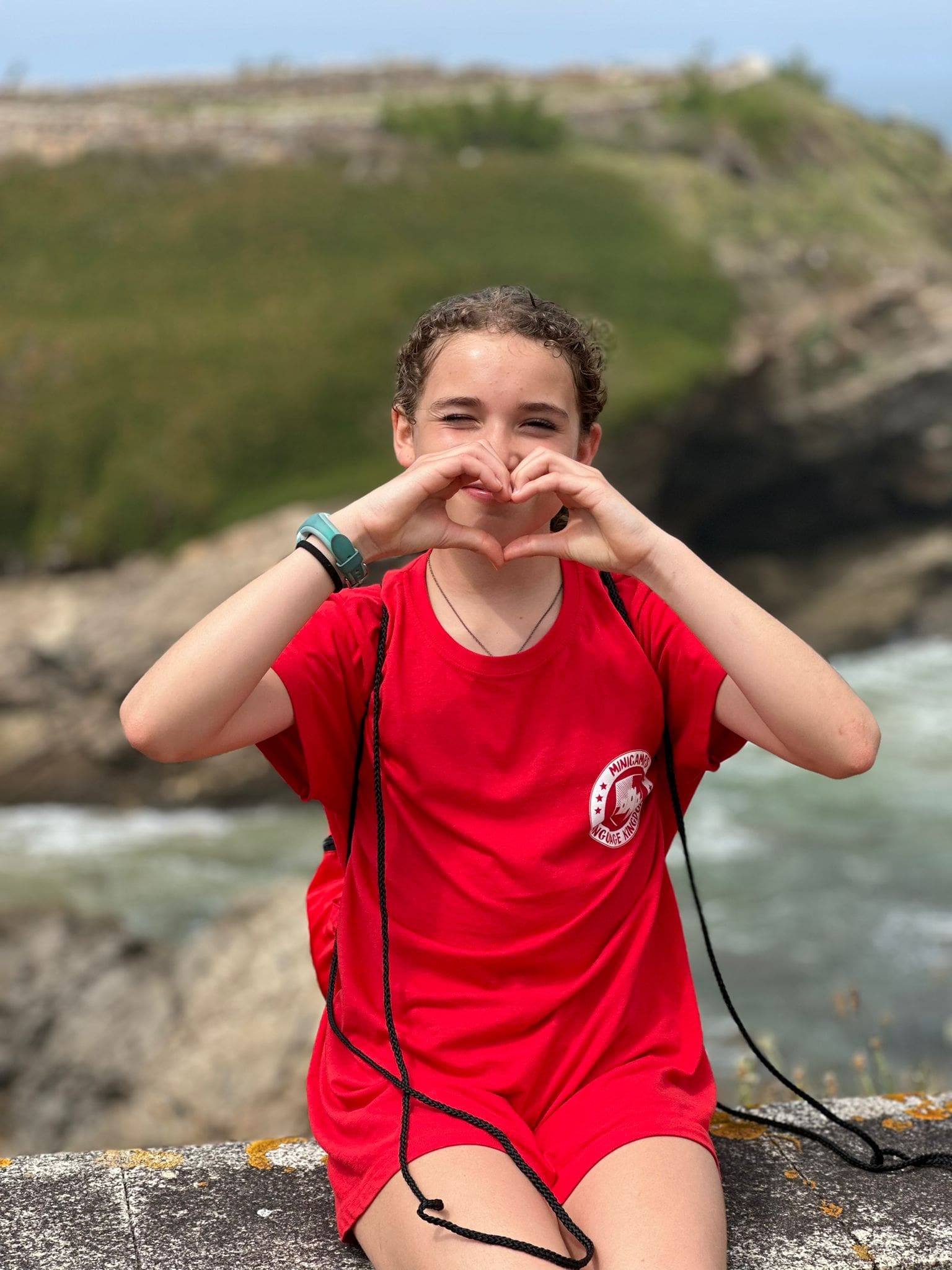 Estudiante haciendo un corazón con las manos en un campamento escolar en el weekcamp de Foz