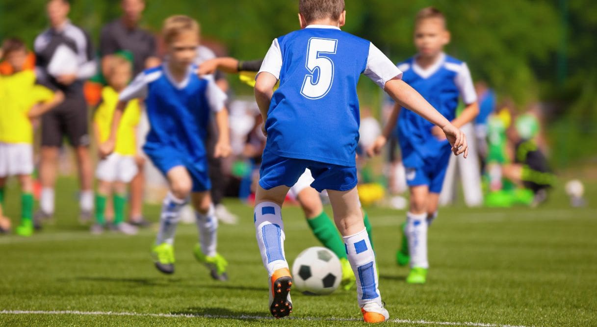 Niños jugando a fútbol en un campo