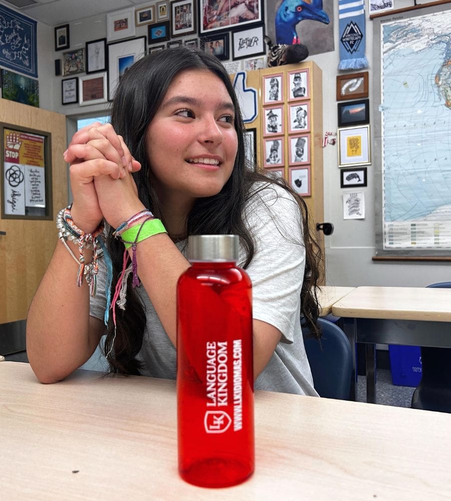 Estudiante con un mapa detrás del mundo en un aula