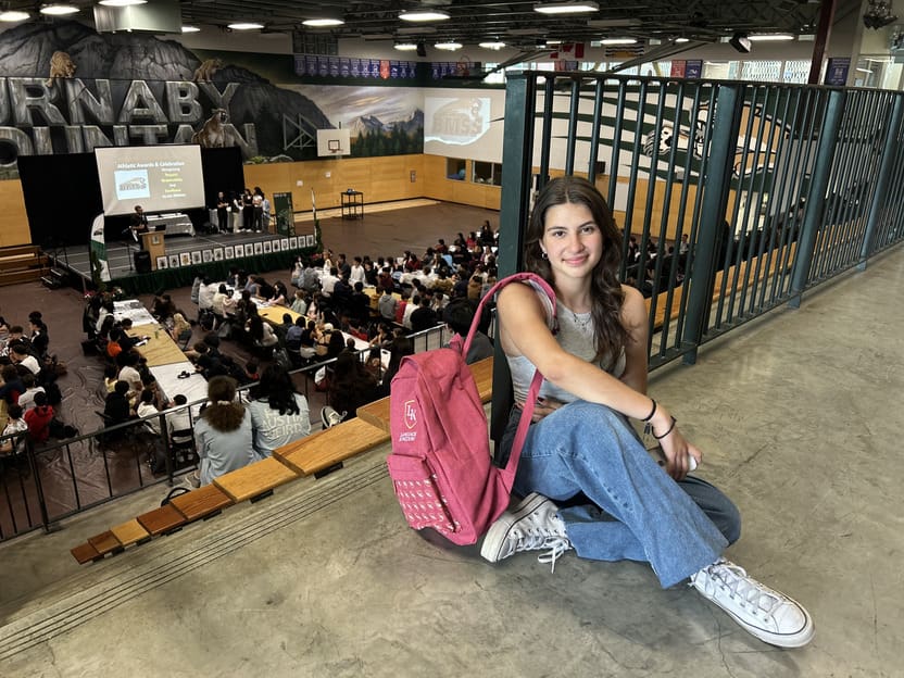 Estudiante LK con su mochila sentada en el suelo