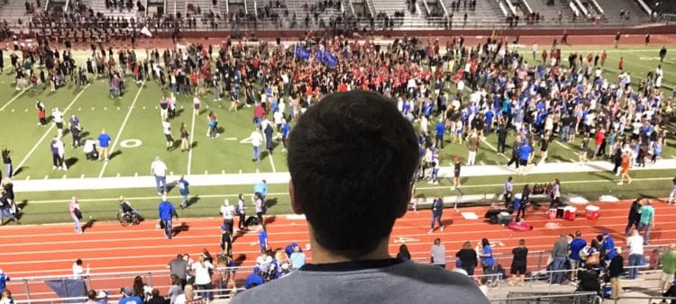 Joven asistiendo a partido en un estadio estadounidense