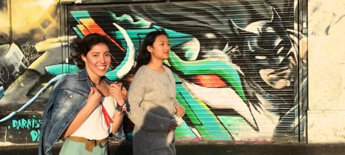 Chicas delante de grafiti caminando en Reino Unido